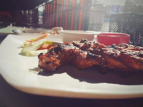 Chicken grill on a plate with light rays falling on it. Stock Photos
