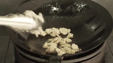 Chicken into hot fire and pan Stock-Footage 88570607