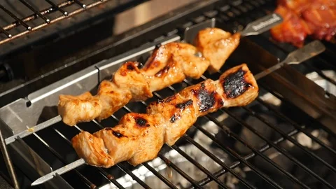 Chicken kebabs cook on a BBQ Stockbeeldmateriaal 115054755