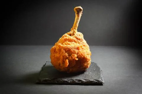 Chicken leg in breaded, on a dark basalt stand Stock Photos