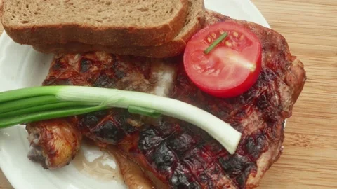 Chicken leg cooked on fire with leek, black bread and tomato 库存影片 194747486