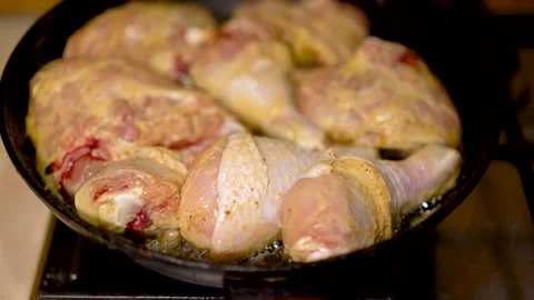 Chicken legs are fried in a large skillet in vegetable oil. Stock Footage 148647799