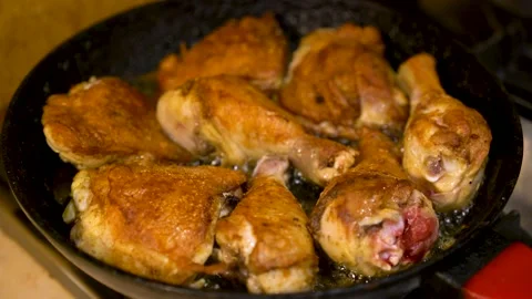 Chicken legs are fried in a large skillet in vegetable oil. Stock Footage 148647916