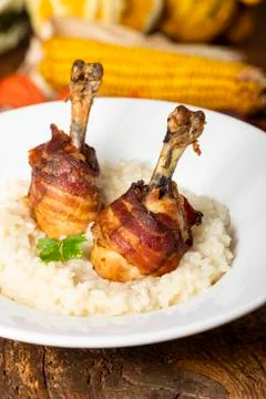 Chicken legs with bacon on risotto Stock Photos