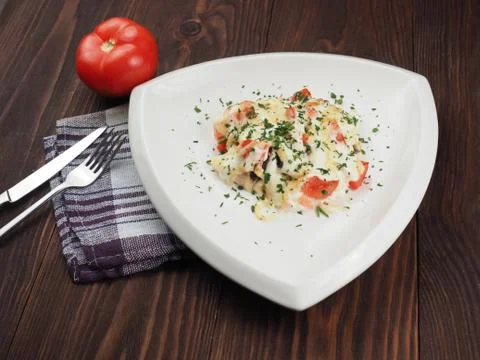 Chicken meat with cheese sauce in a triangular plate on the table Stock Photos
