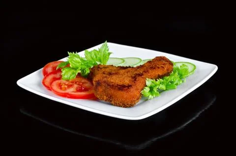 Chicken meat fried in a breaded with fresh vegetables. Black background 写真素材