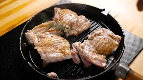 Chicken meat is fried in a pan. The chef adds rosemary to the meat to add flavor Stock Footage 276836419