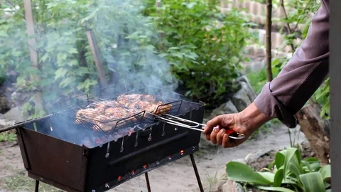 Chicken meat lies in a grid on the grill and roasts the overall plan Stock Footage 100346034