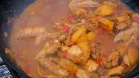 Chicken meat is stewed in a cauldron. The meat is stewed in a cauldron. A dish Stock Footage 280354677
