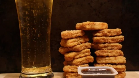 Chicken Nugget Tower with Beer in Frame Real Time Motion Stock Footage 128703980