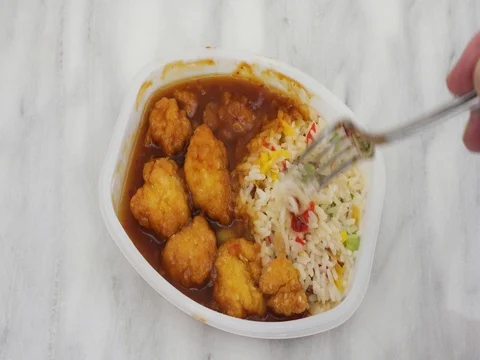 Chicken nugget TV dinner being stirred with a fork Stock Footage 77552335