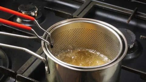 Chicken nuggets in a deep-fat grid are fried in boiling oil. Medium shot. Stock Footage 309897063