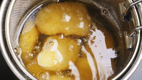 Chicken nuggets in a deep-fat griddle are fried in boiling oil on the stove.. Video stock 309897121