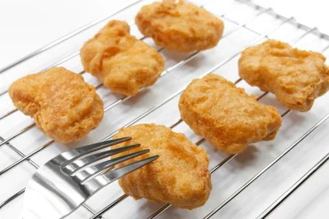 Chicken nuggets with fork on grille Stock Photos