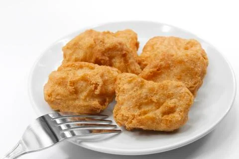 Chicken nuggets with fork on white plate Stock Photos