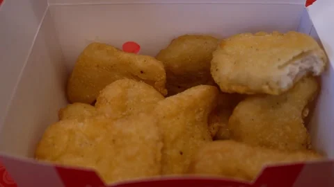 Chicken nuggets in a paper box close-up. Hand taking nuggets from paper box on t Stock Footage 270895438