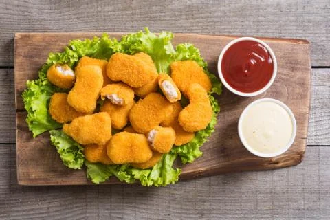 Chicken nuggets in plate on rustic background Stock Photos