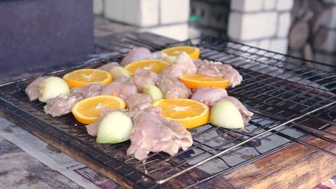 Chicken with onions and oranges spread on the grill for a barbecue Vidéo 91352226