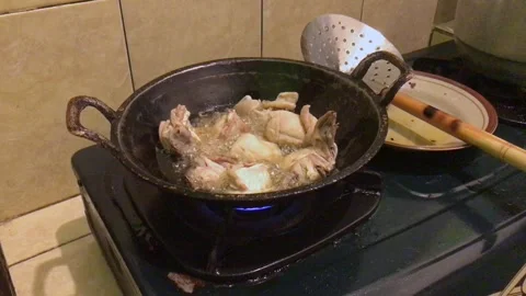 Chicken Pieces Deep Frying in Hot Oil in a Traditional Black Wok on Gas Stove Video stock 346159576