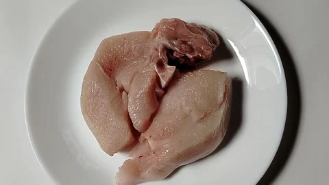 Chicken pieces on a plate, a basic ingredient in a food menu. Video stock 329466426