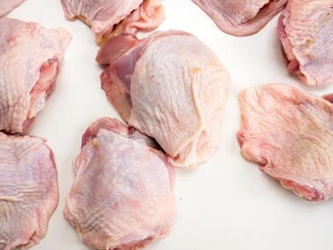 Chicken pieces on a white table. Stock Photos