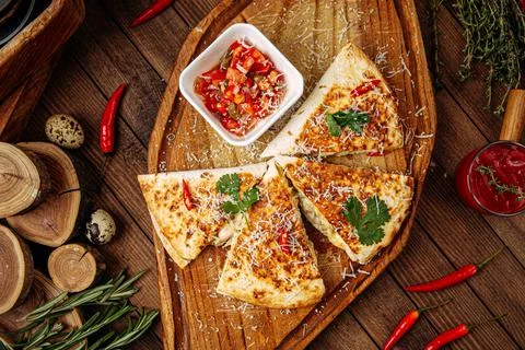 Chicken quesadilla with salsa sauce on serving board Stock Photos