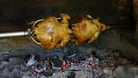 Chicken roasted on spit being grilled over the bright glowing coals. Stock Footage 162463923