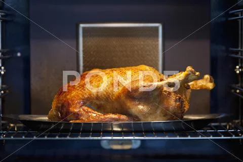 A Chicken Roasting In An Oven