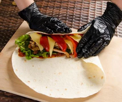 Chicken roll in the cooking process. Wrapping the filling into a flapjack Foto stock