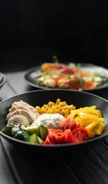 Chicken salad with cherry tomatoes, corn, cucumber and mayonnaise for mixing Stock Photos