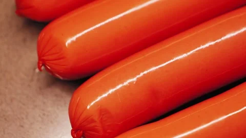 Chicken sausages wrapped in plastic or mica. Close up of semi-finished meat Stock Footage 335807011