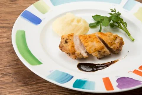 Chicken saute balsamic source on white plate with herbs Stock Photos