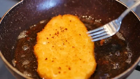 Chicken Schnitzel cooked in oil on the stove, large Chicken Schnitzel, 動画素材 166322719