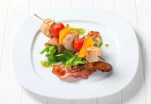 Chicken skewer and string beans wrapped in bacon Stock Photos