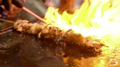 Chicken skewered like satay grilled using hand held gas Stock Footage 272297591