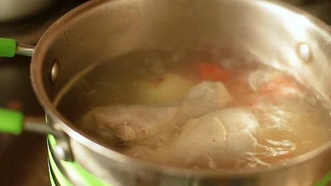 Chicken soup with vegetables boiling in a pot close-up Stock Footage 118402262