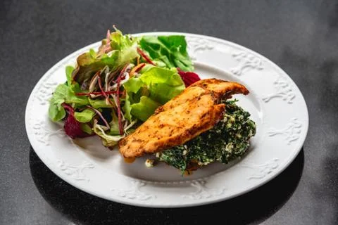 Chicken Spinach with salad on table Stock Photos