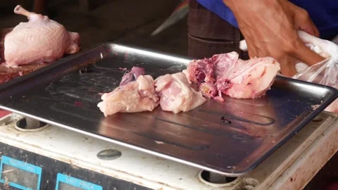 Chicken traders wrap fresh chicken pieces in plastic Stock Footage 310248473