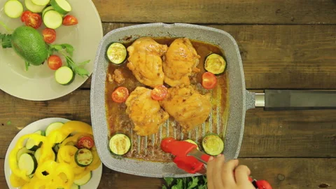 Chicken with vegetables is fried in a grill pan. 库存影片 111073222