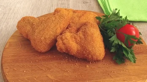 Chicken wing in breading falls on serving board slow motion footage Video stock 78441141