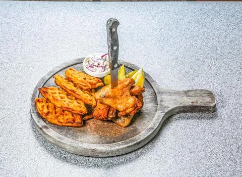 Chicken Wings and Waffles Includes a knife stuck in the food a side of cole.. Stock Photos