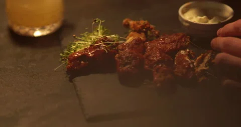 Chicken wings are cooked, lying on a plate in the restaurant, ready to eat. Stock-Footage 241180048