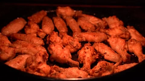 Chicken wings on a baking sheet while being roasted in the oven Stock Footage 246720285