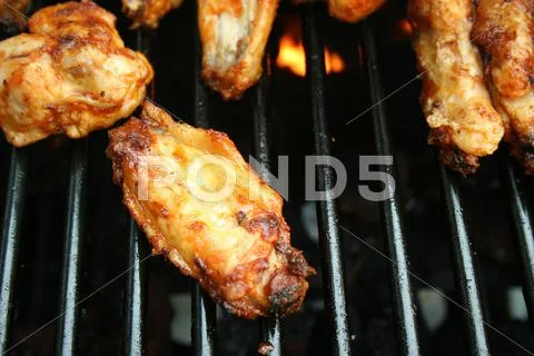 Chicken wings cooking on the grill Stock Photos