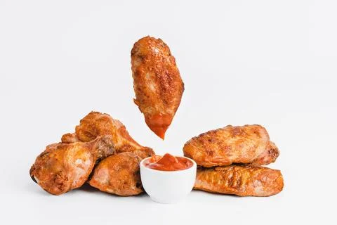 Chicken wings fried until half cooked, semi-finished product with fresh herbs on Stock Photos