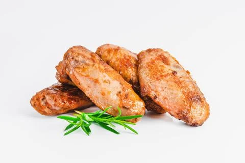 Chicken wings fried until half cooked, semi-finished product with fresh herbs on Stock Photos