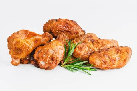 Chicken wings fried until half cooked, semi-finished product with fresh herbs on Stock Photos
