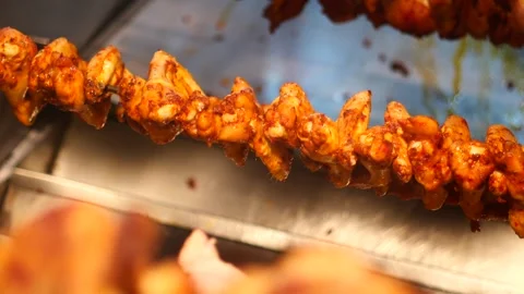 Chicken wings on spit roasting in slow motion with red marinade. 스톡 동영상 332268519