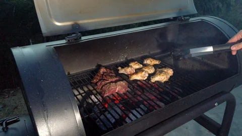 Chicken Wings on the Summer BBQ. But do not forget those Pieces of Hanging Stock Footage 108463726