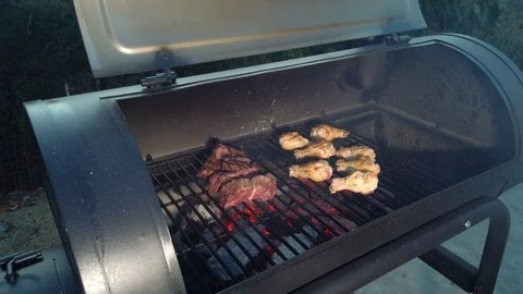 Chicken Wings on the Summer BBQ. But do not forget those Pieces of Hanging Stock Footage 108463794